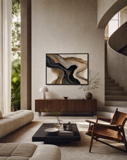 Abstract framed wall art with flowing black, beige, and brown organic shapes, displayed in a modern living room above a wooden console table.