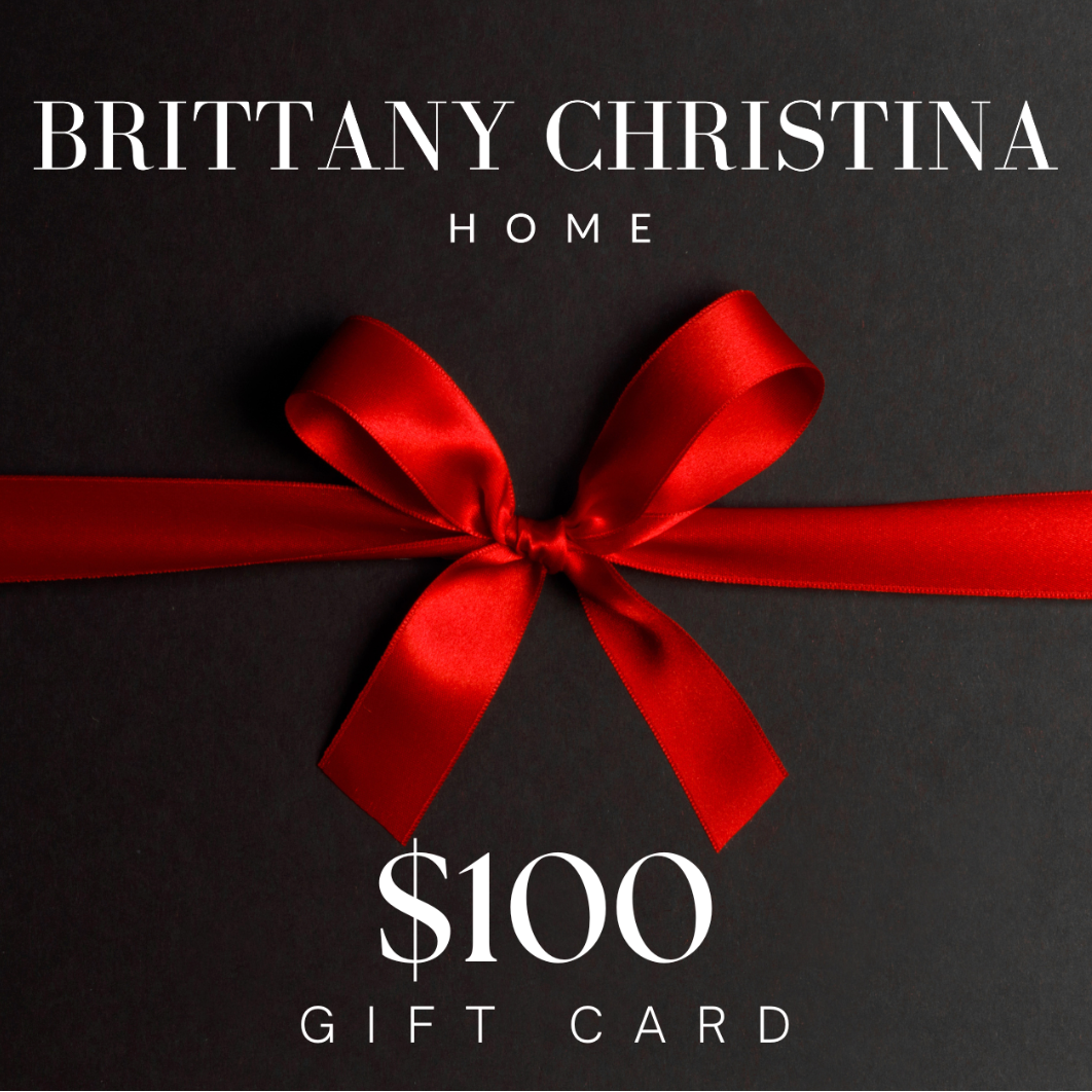 Black gift card with red ribbon and text 'BRITTANY CHRISTINA HOME $100 GIFT CARD' on a beige background.