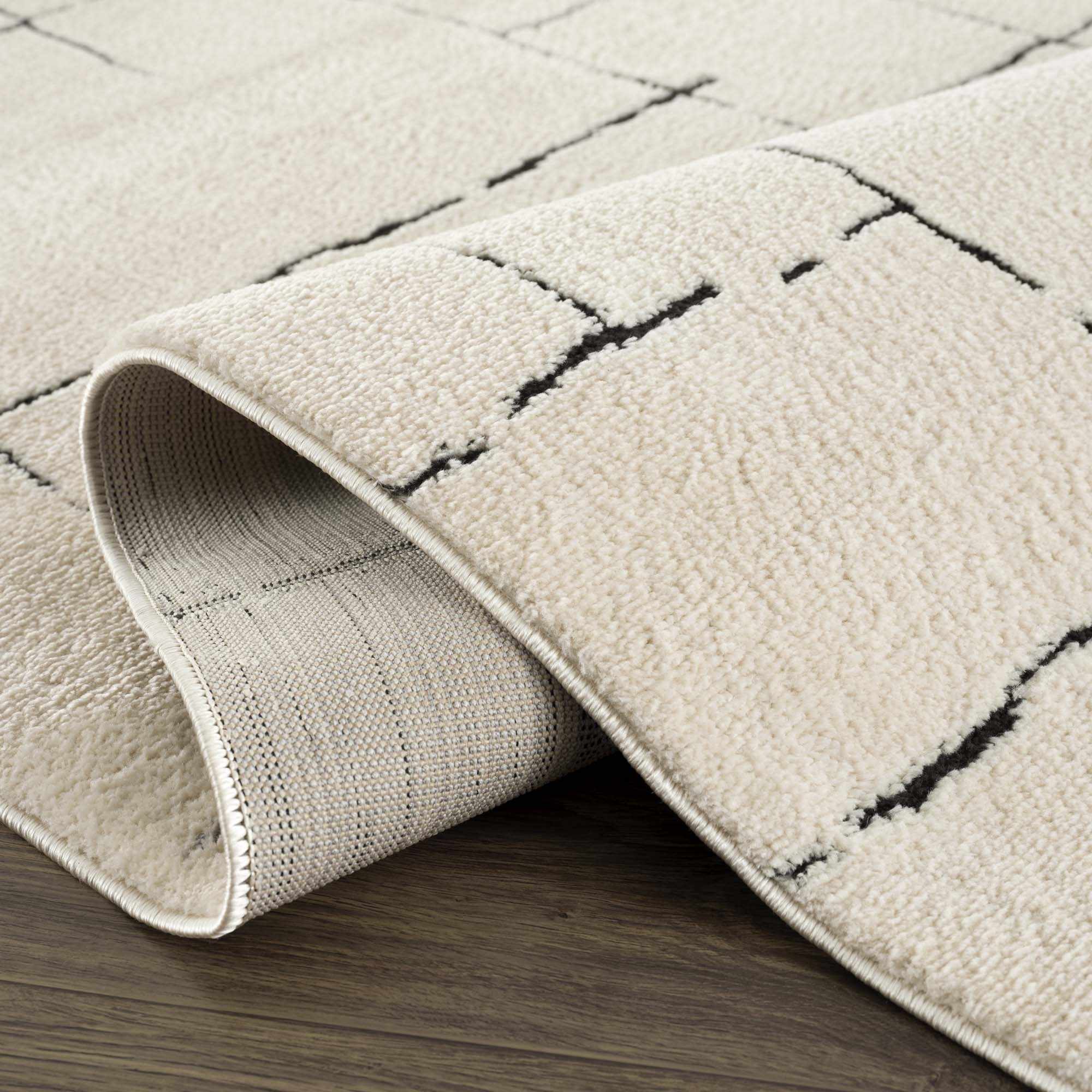 Textured beige rug with geometric pattern on a wooden floor