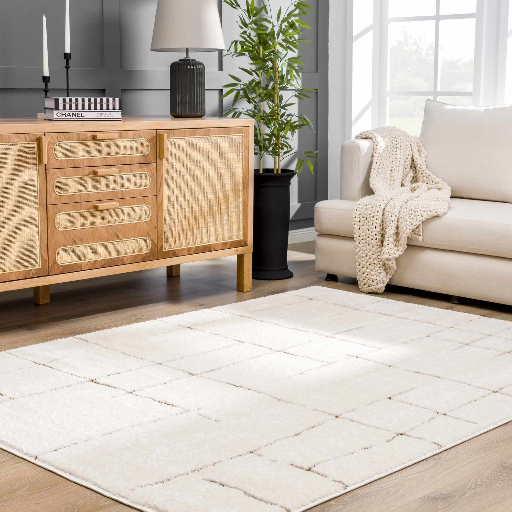 Living room with a beige sofa, wooden sideboard, and white rug.