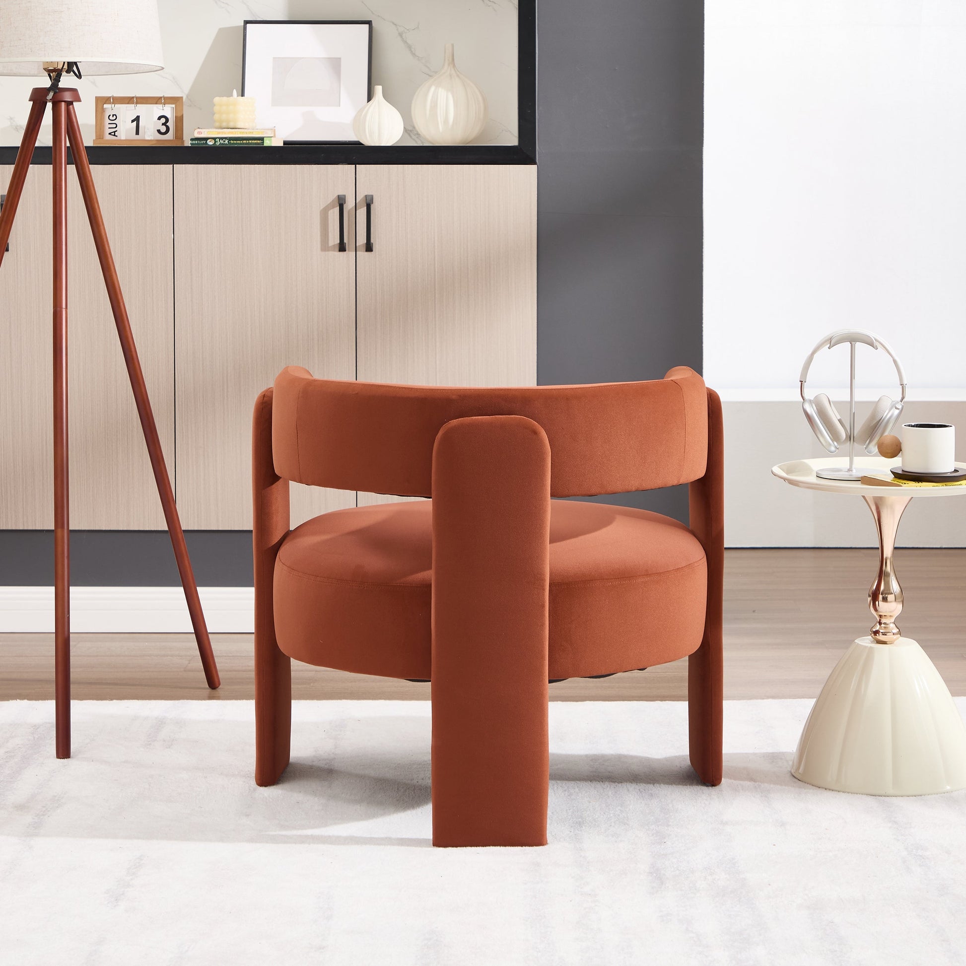 Modern orange chair in a stylish room with decor elements.