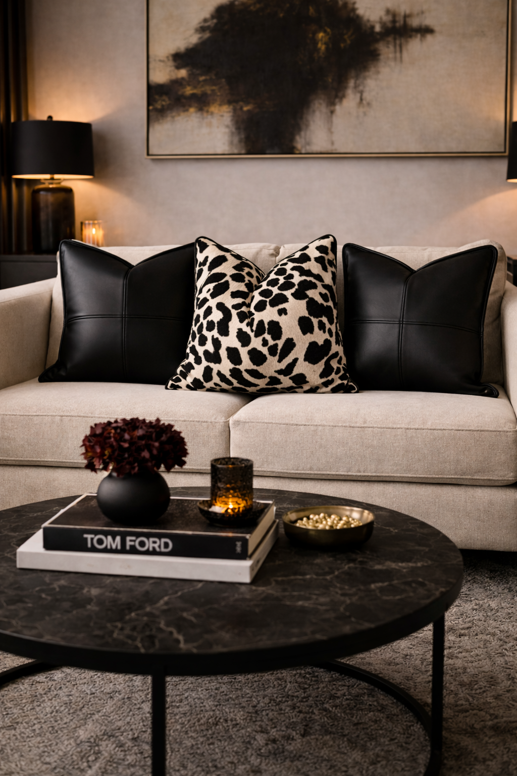 Modern living room with a gray sofa, decorative pillows, and a coffee table with a book and candles.